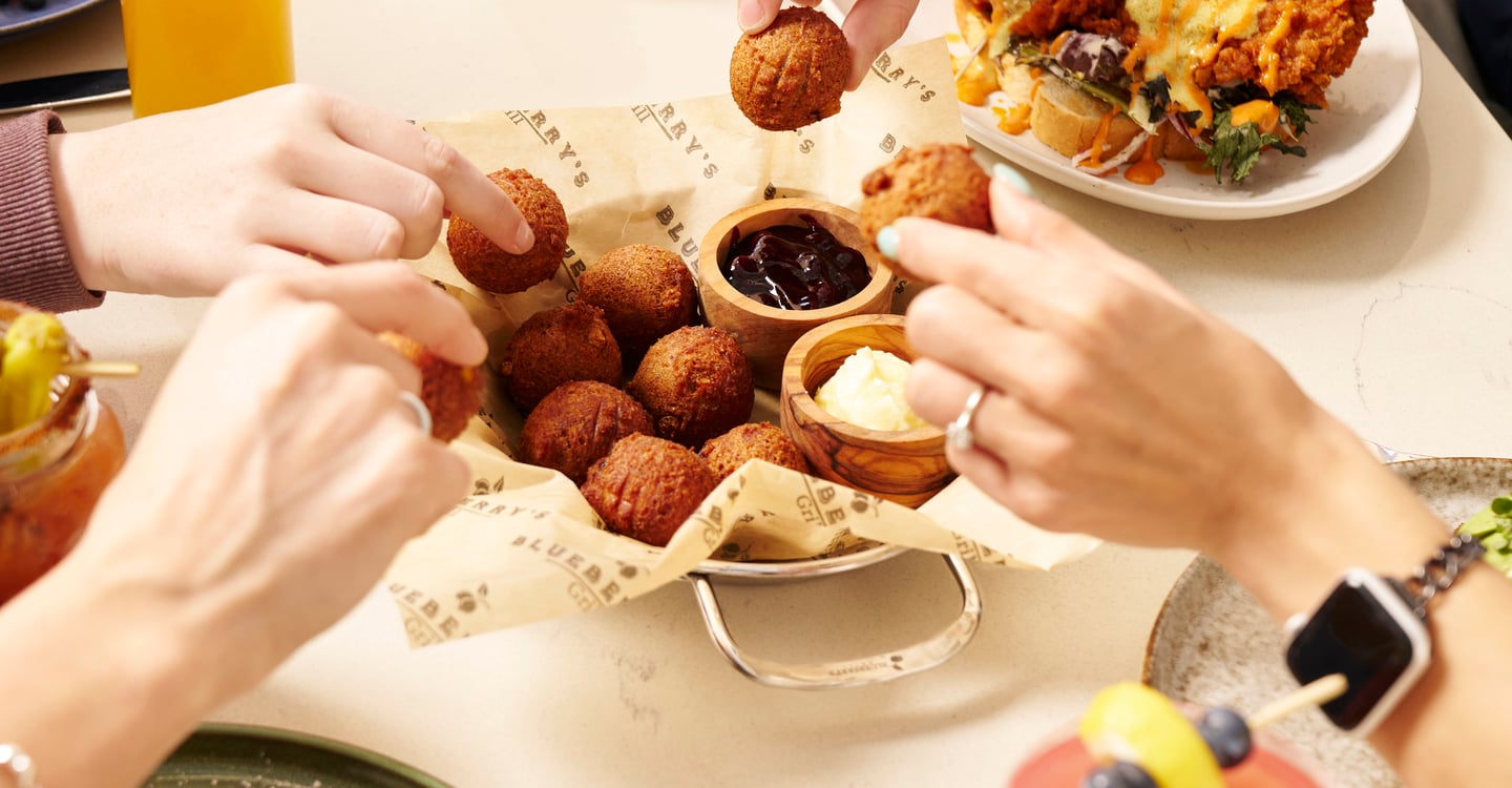 A family sharing brunch plates at a big table at Blueberry's Grill